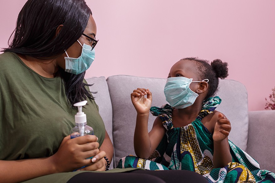 African American mother and daughter wearing a mask are washing their hands with alcohol to protect them from germs and COVID-19 while staying at home. Chayantorn/iStock photo