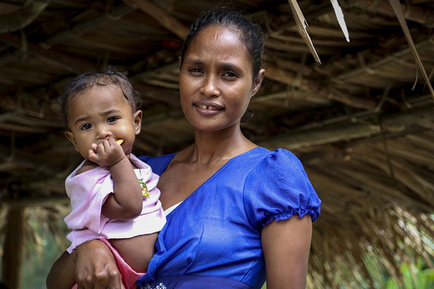 Eliza da Costa Martins, 34, pictured in Libagua village, Timor Leste, with her daughter, Cidalria da Costa Magno, 1. Anna Djahova/CRS